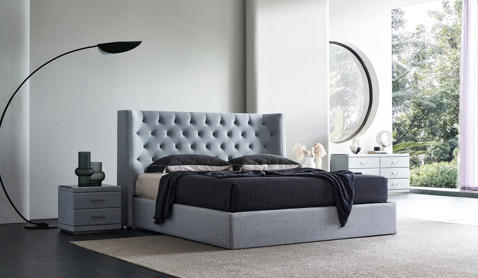 Dormitorio principal a medida con cama de tapizado gris capitoné y mesitas de noche en una villa.