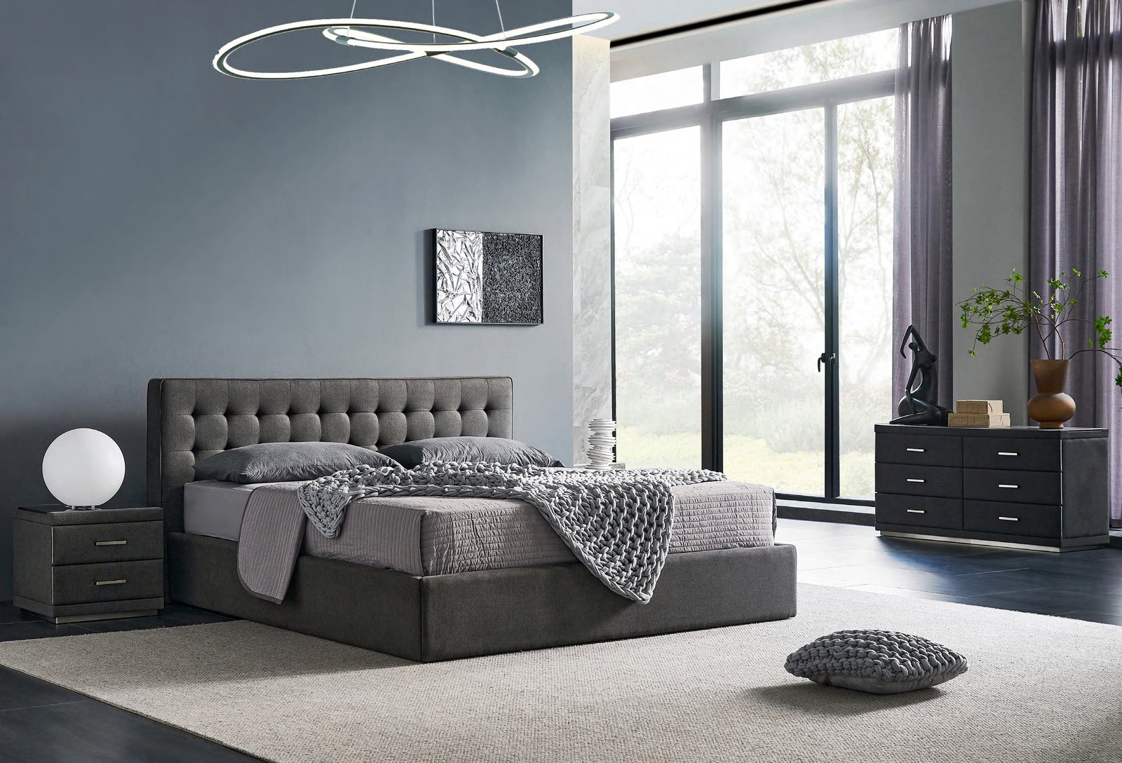 Cama con cabecero tapizado en gris con capitoné entre dos mesillas de noche con lámparas esféricas