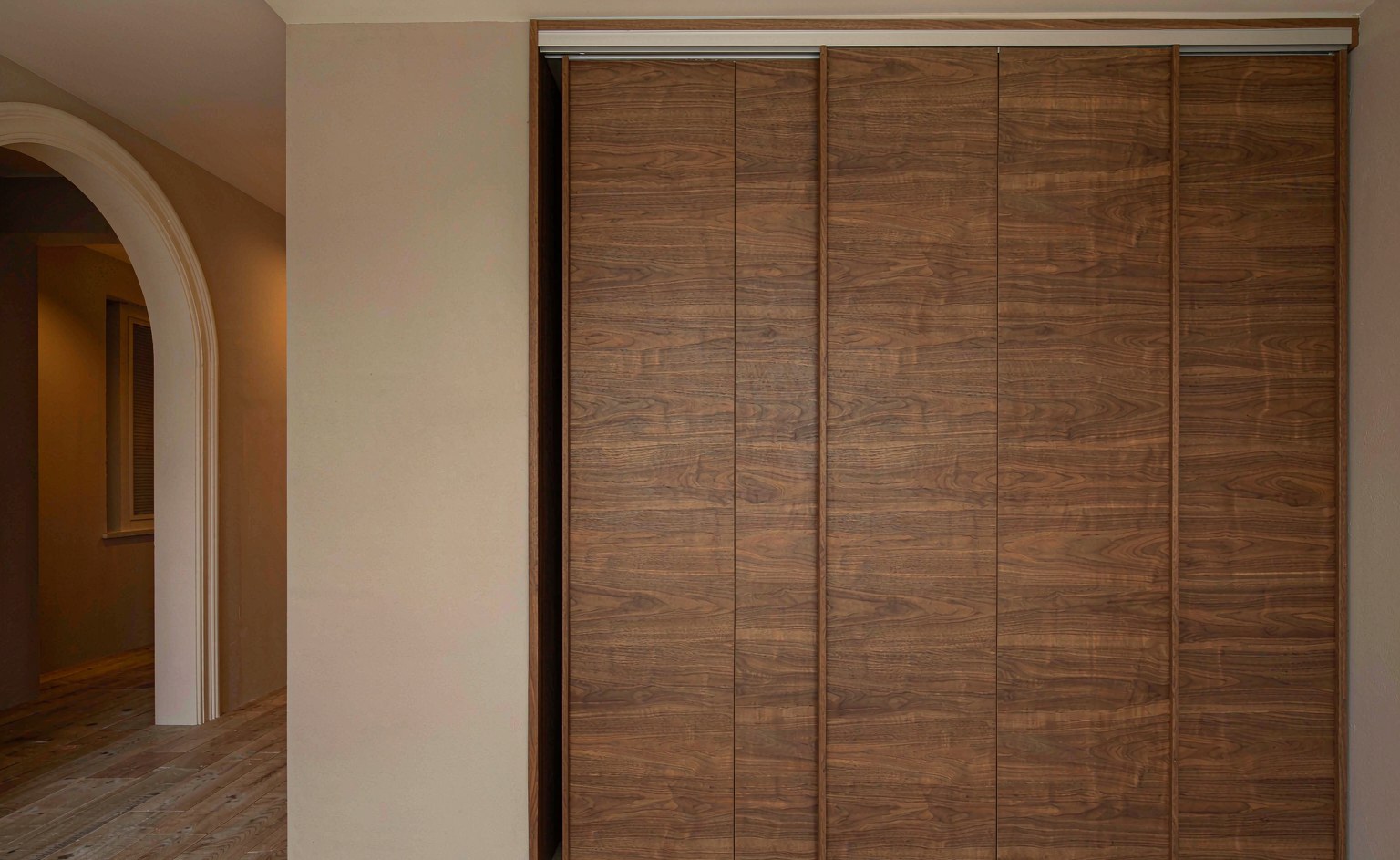 Frente de armario empotrado con puertas correderas de madera en un dormitorio de villa