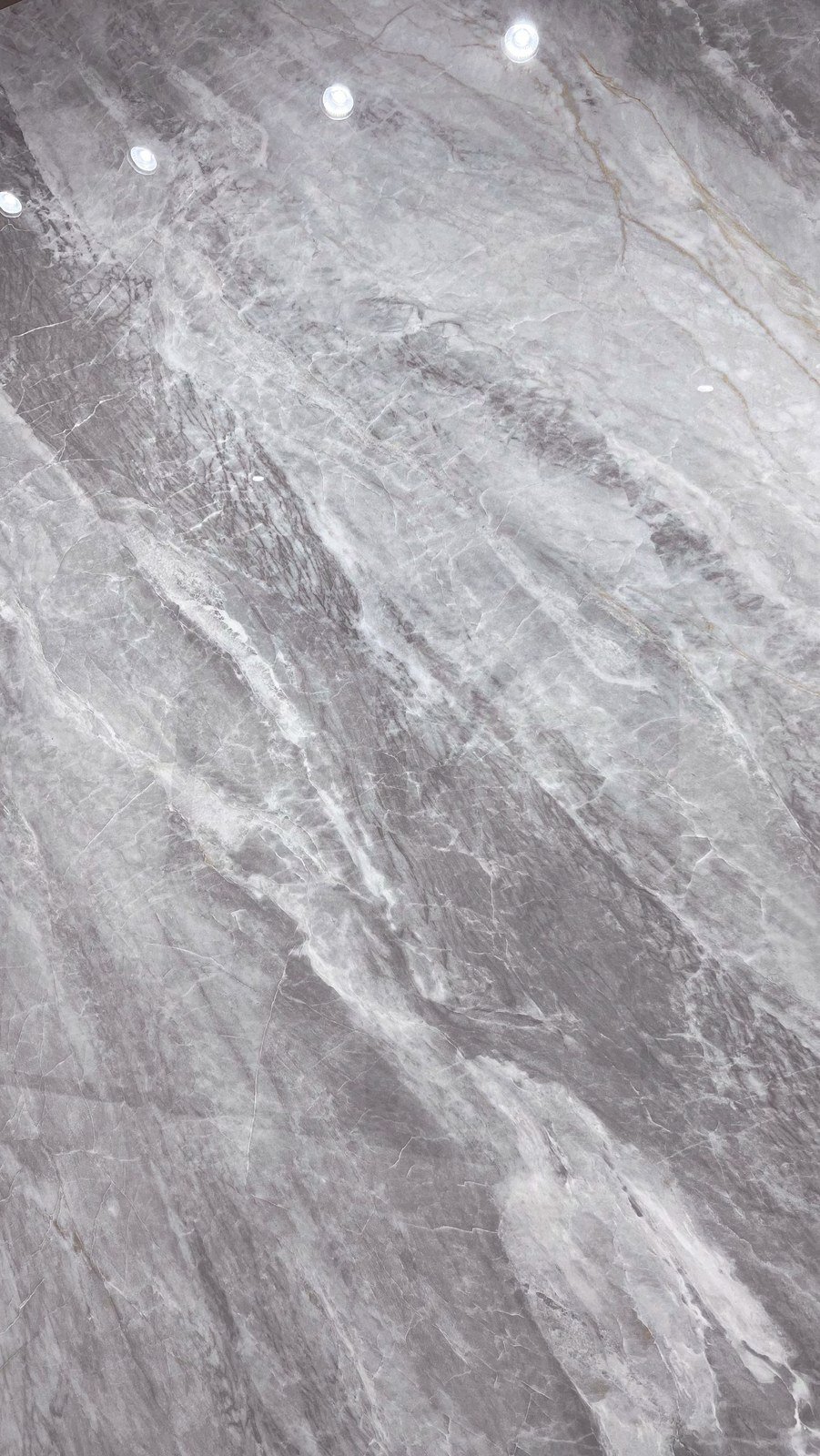 Losa de piedra de gran formato con veta gris para encimera o mesa de mueble a medida.