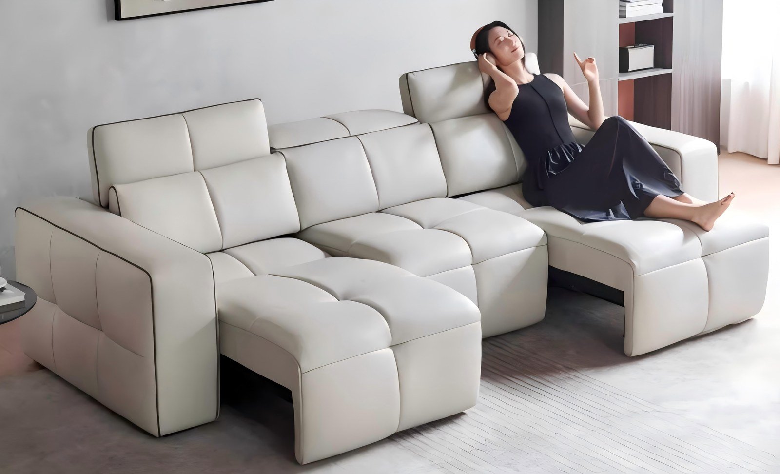 Sofá modular de piel blanca con chaise longue en un salón residencial luminoso.