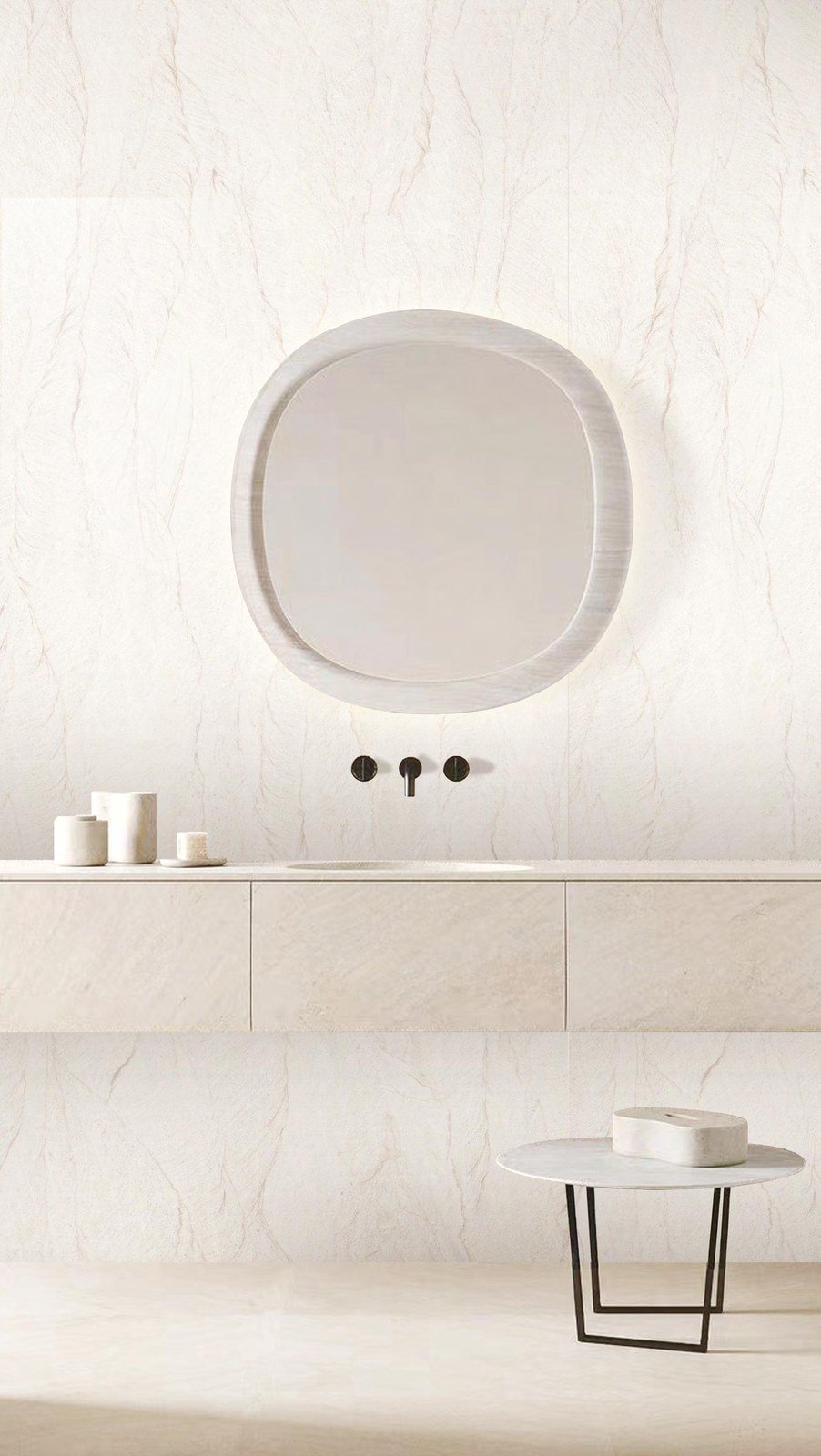 Mueble de baño a medida con encimera de piedra clara y espejo redondo.