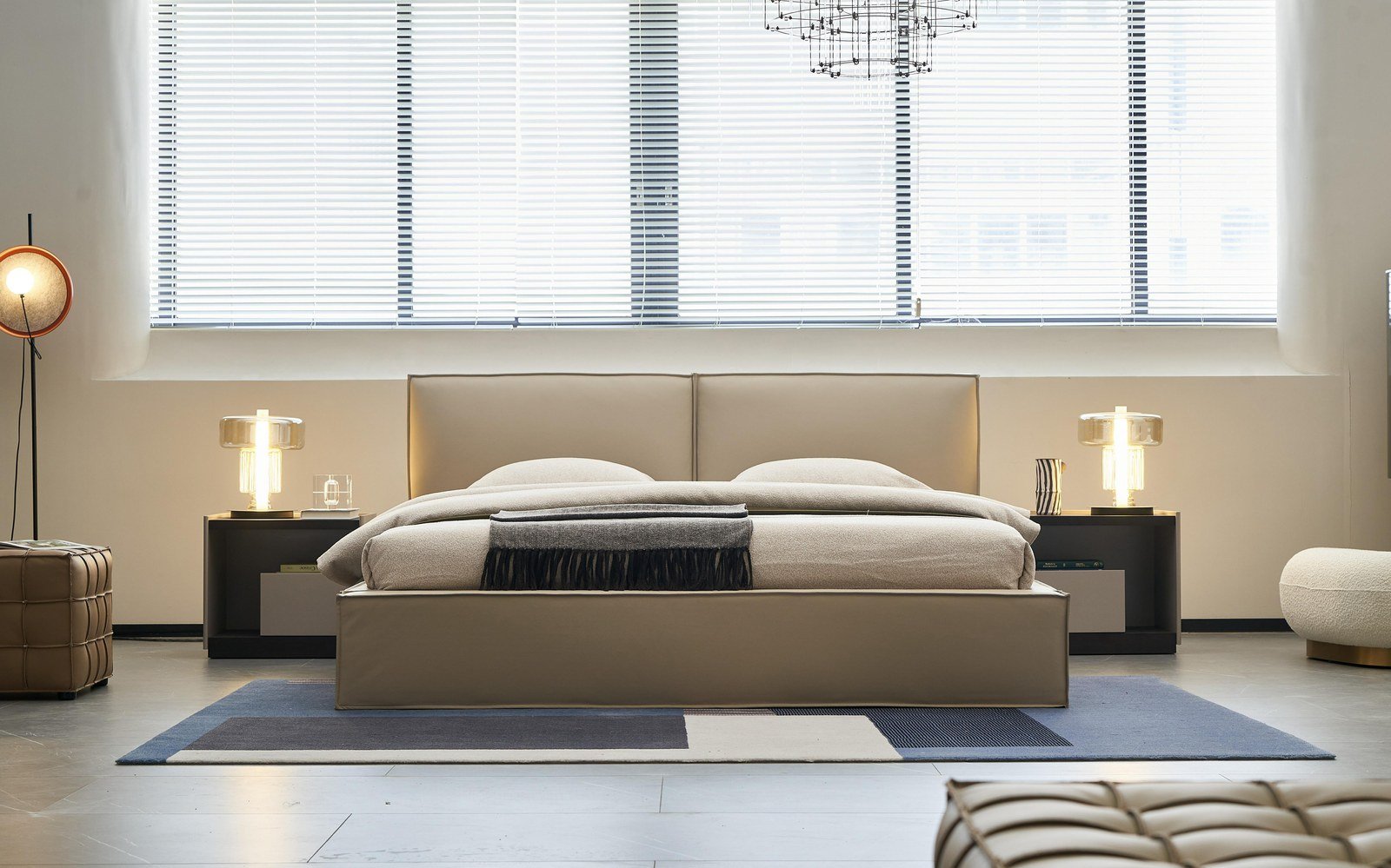 Cama a medida con cabecero de piel color arena y mesillas de noche en un dormitorio principal de villa.