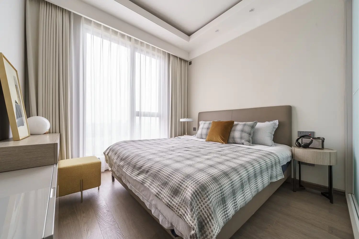 Dormitorio pequeño con cama matrimonial, mesa de noche y cómoda con espejo