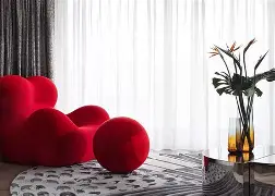Puff decorativo en forma de corazon color rojo con textura aterciopelada en sala moderna - asiento informal