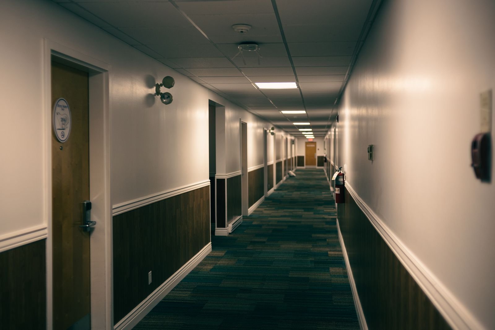 Pasillo de hotel con bancas de madera e iluminación cálida